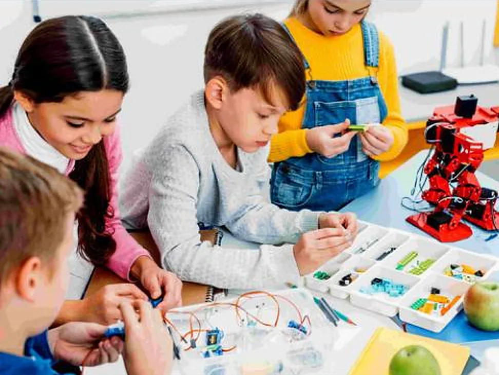 Crianças montando e programando um robô na aula de Robótica